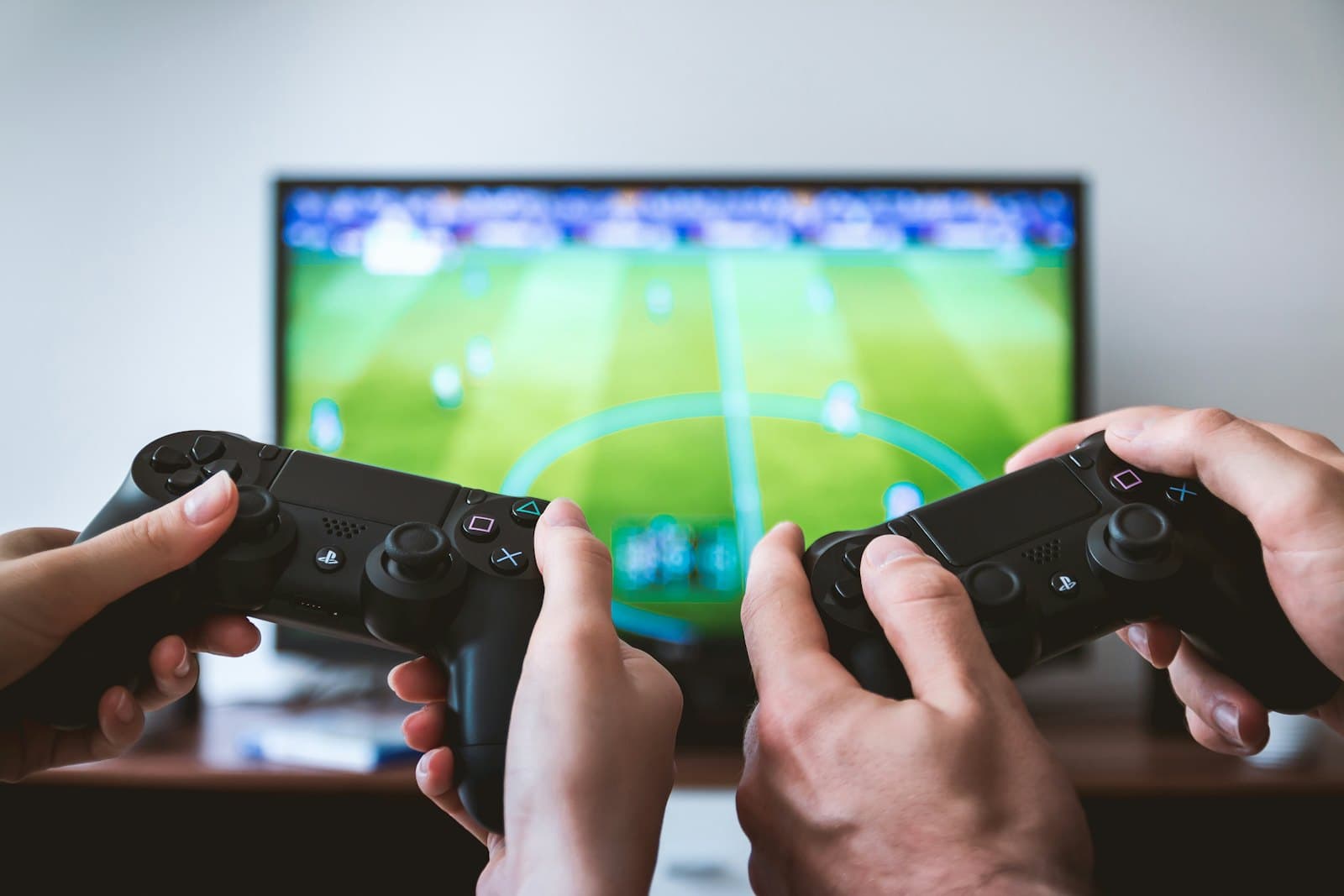 two people holding game controllers, playing a game on a television